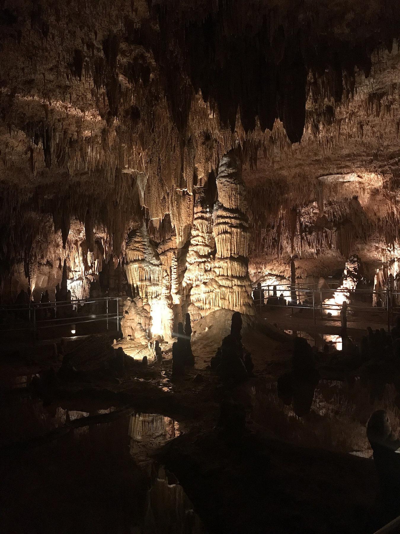 Lit formations reflected in water inside Onondaga Cave, Missouri