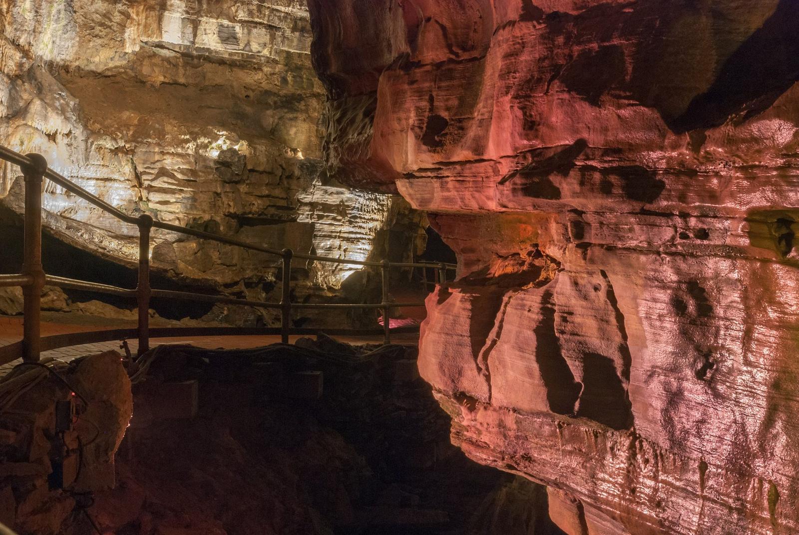 Lit passage and railing inside Howe Caverns, New York